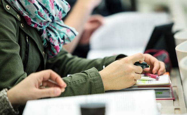 Studierende im Hörsaal, Nahaufnahme Hände